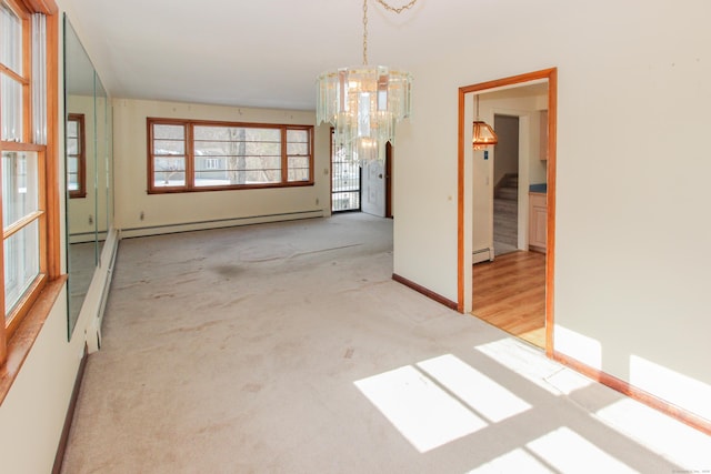 carpeted spare room featuring baseboard heating and a notable chandelier