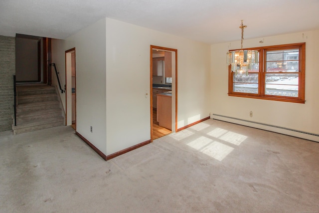 spare room with a baseboard heating unit, light colored carpet, and an inviting chandelier