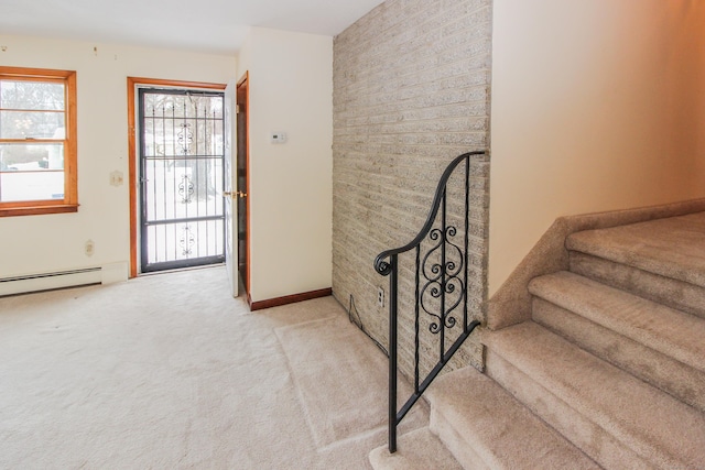 carpeted entryway featuring a baseboard radiator and a wealth of natural light