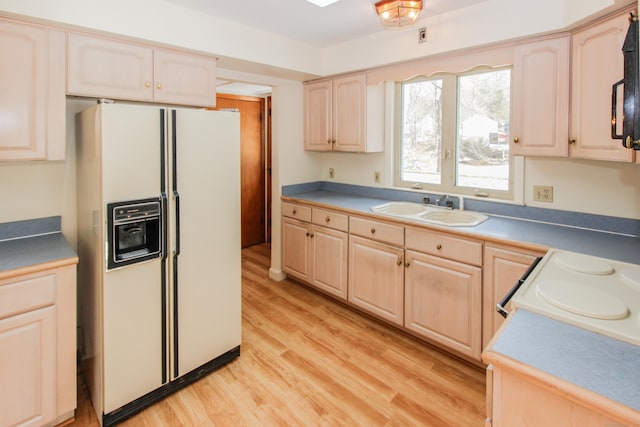 kitchen with white fridge with ice dispenser, sink, light brown cabinetry, and light hardwood / wood-style floors