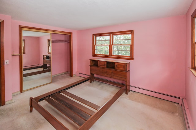 carpeted bedroom featuring baseboard heating and a closet