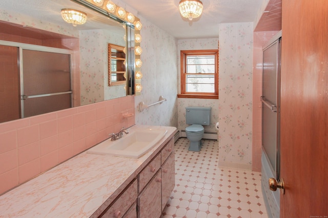 full bathroom with vanity, a baseboard heating unit, bath / shower combo with glass door, and toilet