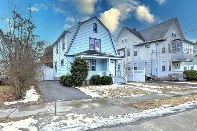 view of front of home with a garage, an outdoor structure, and covered porch