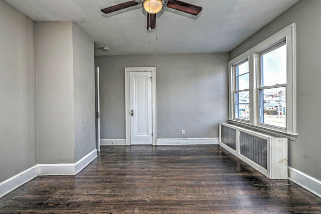 unfurnished room with dark wood-type flooring, radiator heating unit, and ceiling fan