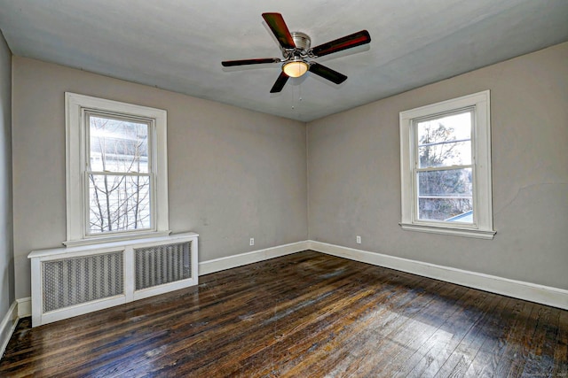 spare room with ceiling fan, radiator heating unit, and dark hardwood / wood-style flooring