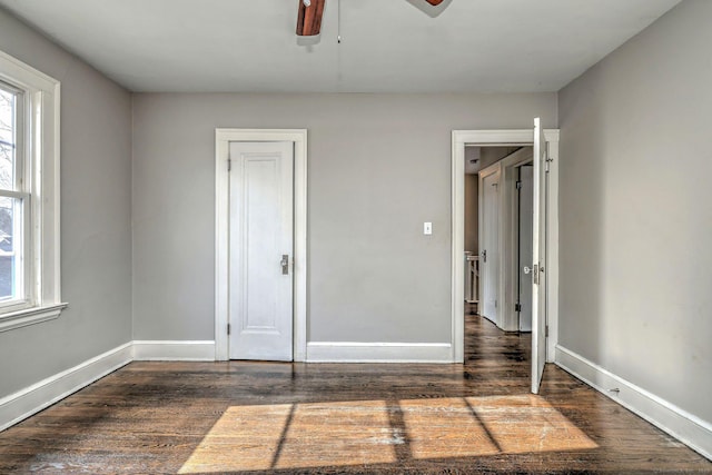 unfurnished bedroom featuring dark wood-type flooring and ceiling fan