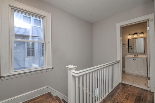 corridor with dark hardwood / wood-style flooring and sink