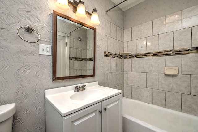 full bathroom with tiled shower / bath combo, vanity, and toilet