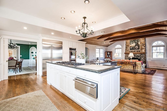 kitchen featuring white cabinetry, a center island, a chandelier, and a wealth of natural light