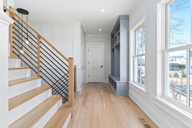 interior space with ornamental molding and light hardwood / wood-style floors