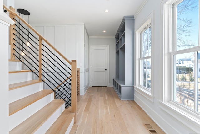 interior space with crown molding, visible vents, baseboards, recessed lighting, and light wood-style flooring