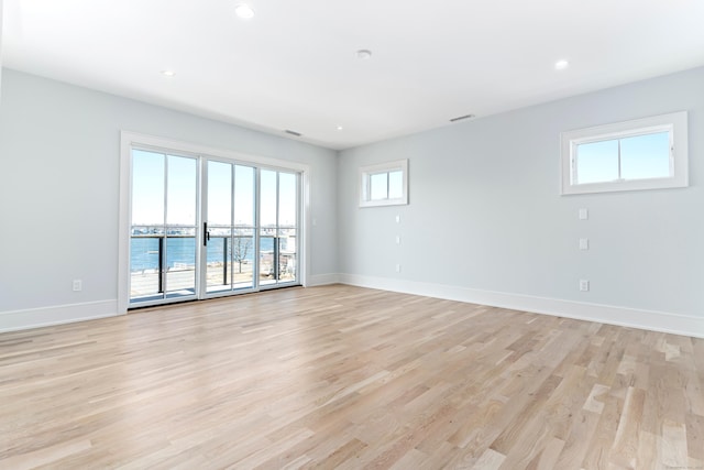 empty room with a water view and light wood-type flooring