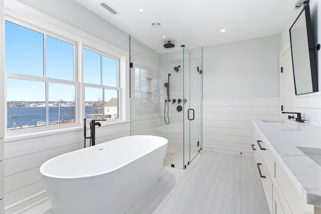 full bath with visible vents, a freestanding tub, a stall shower, a water view, and recessed lighting