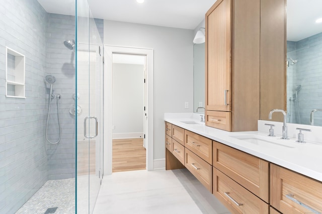 full bathroom with double vanity, a sink, a stall shower, and recessed lighting