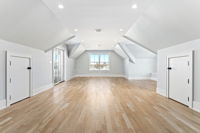 additional living space featuring lofted ceiling and light wood-type flooring