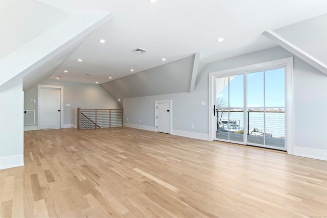bonus room with baseboards, vaulted ceiling, visible vents, and light wood-style floors