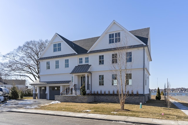 view of front of house featuring a garage, roof with shingles, a standing seam roof, metal roof, and driveway