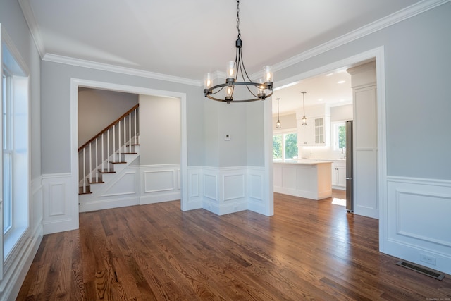 unfurnished dining area with ornamental molding, dark hardwood / wood-style floors, and a notable chandelier