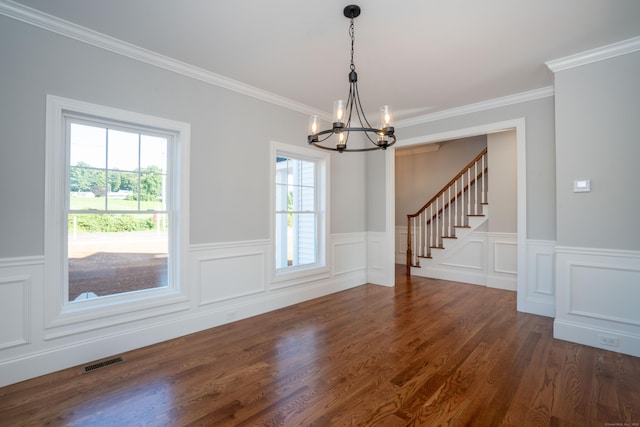 unfurnished dining area with dark wood-type flooring, ornamental molding, a healthy amount of sunlight, and a chandelier