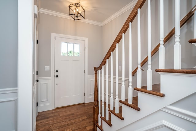 entryway featuring an inviting chandelier, crown molding, and dark hardwood / wood-style floors