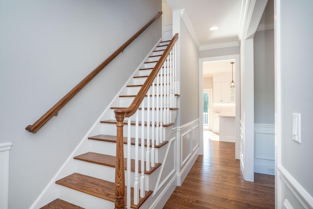 stairs featuring crown molding and wood-type flooring