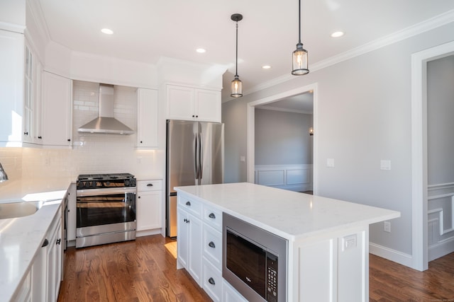 kitchen with stainless steel appliances, light stone counters, white cabinets, a kitchen island, and wall chimney exhaust hood