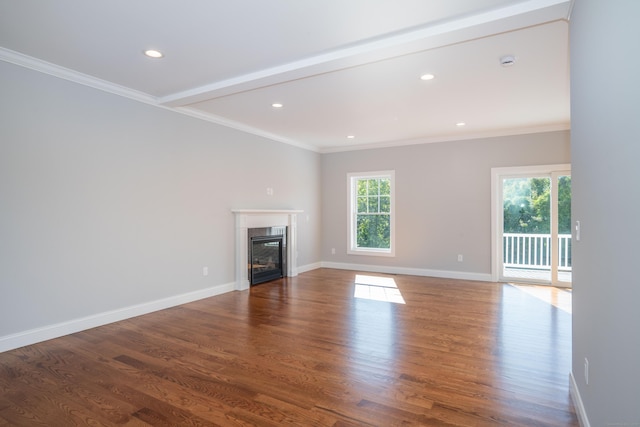 unfurnished living room featuring crown molding, a healthy amount of sunlight, and wood-type flooring