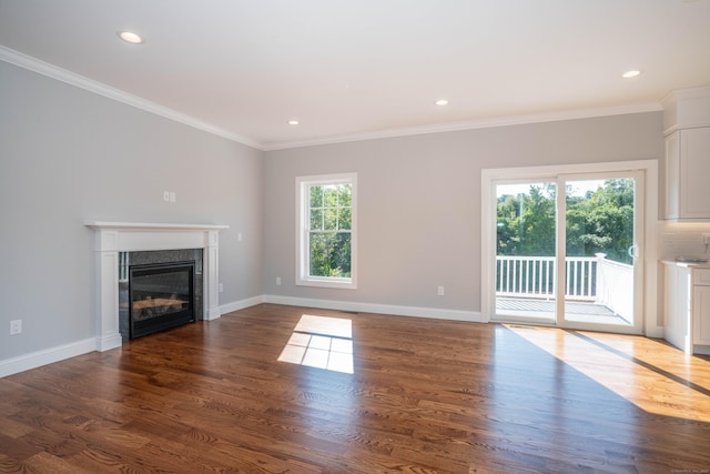 unfurnished living room featuring crown molding, plenty of natural light, and dark hardwood / wood-style flooring