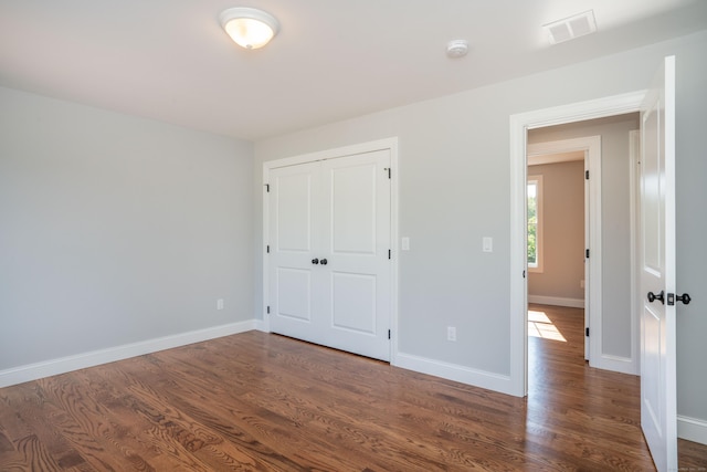 unfurnished bedroom featuring dark hardwood / wood-style floors and a closet