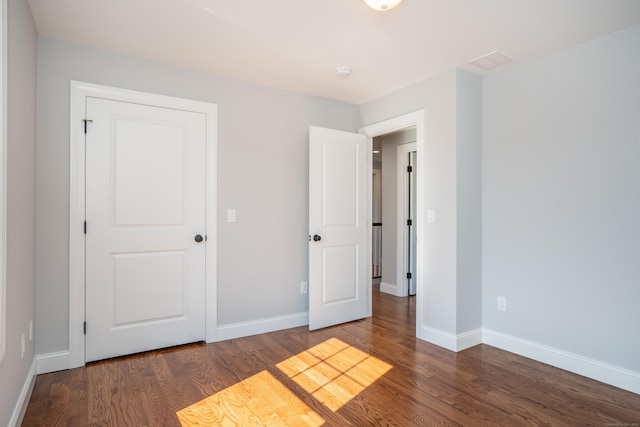 unfurnished bedroom with dark hardwood / wood-style floors