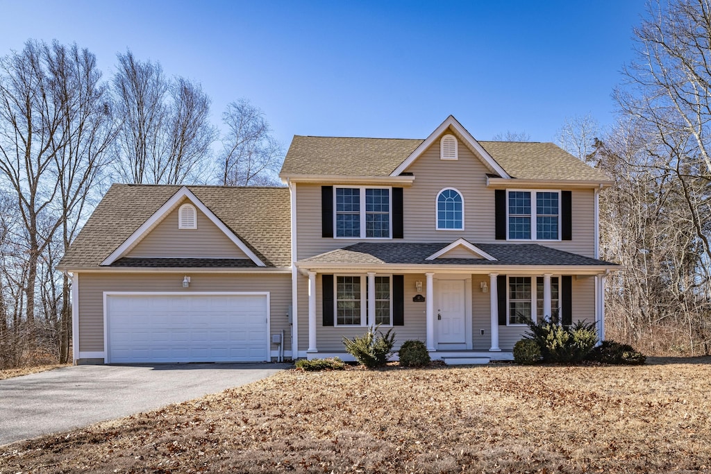 view of front of house featuring aphalt driveway, an attached garage, a porch, and roof with shingles