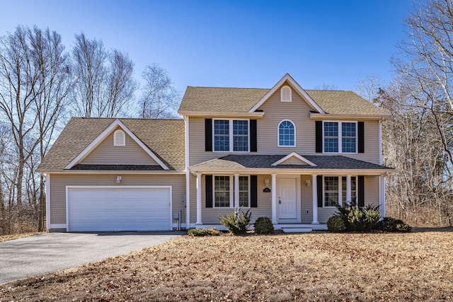 view of front of house featuring aphalt driveway, an attached garage, a porch, and roof with shingles