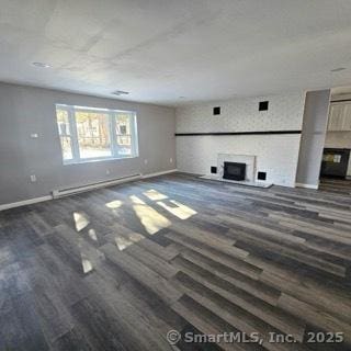 unfurnished living room featuring a baseboard radiator and dark hardwood / wood-style flooring