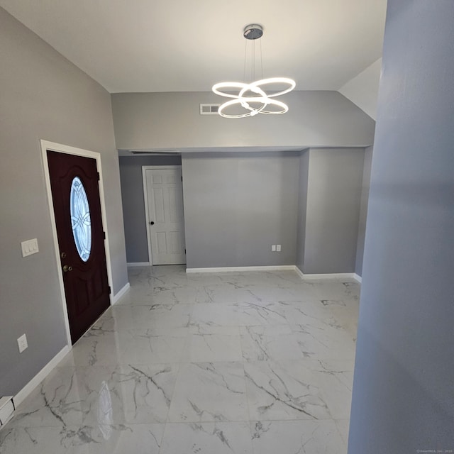 entrance foyer featuring lofted ceiling and an inviting chandelier