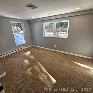 carpeted empty room with baseboard heating