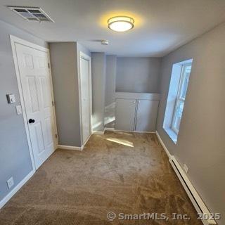 carpeted spare room with baseboard heating