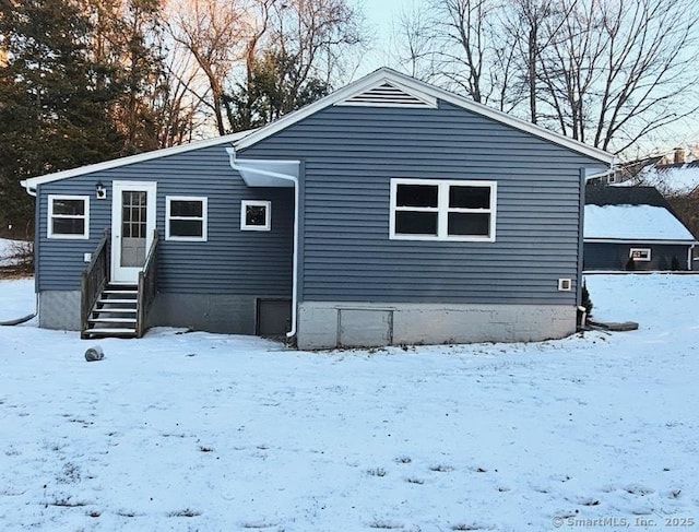 view of snow covered back of property