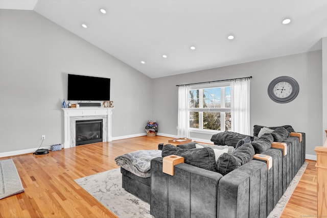 living room featuring lofted ceiling and hardwood / wood-style flooring