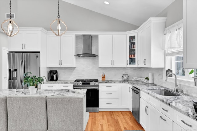 kitchen featuring stainless steel appliances, sink, wall chimney range hood, and white cabinets