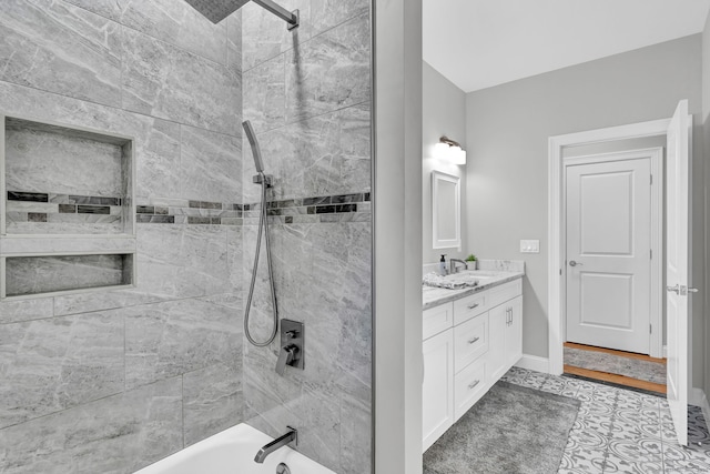 bathroom with tiled shower / bath and vanity