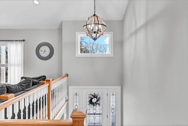 stairs featuring a notable chandelier