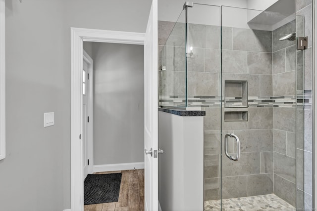 bathroom featuring a shower with door and hardwood / wood-style floors