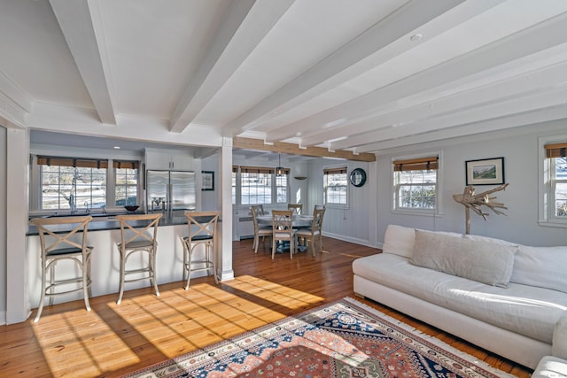 living room featuring beam ceiling and wood-type flooring