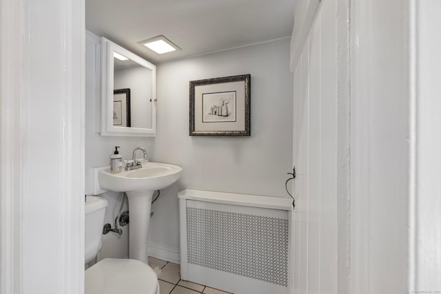 bathroom featuring tile patterned floors, toilet, and radiator