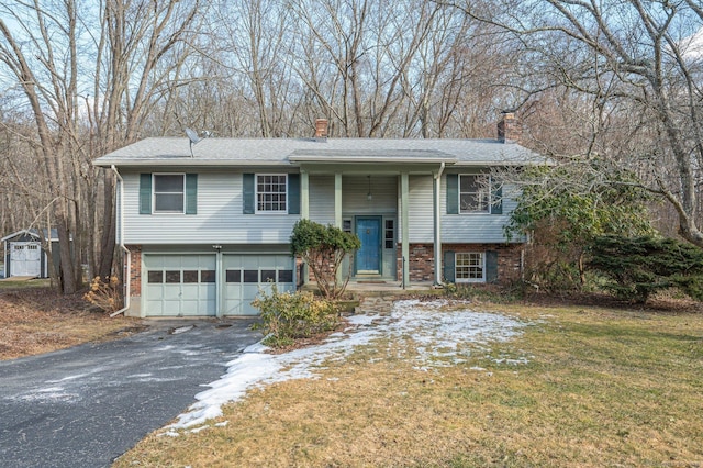 bi-level home featuring a garage and a front yard