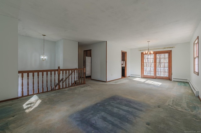 spare room with a baseboard radiator, carpet flooring, and a notable chandelier