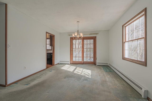 carpeted empty room featuring a chandelier and baseboard heating