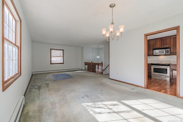 empty room featuring carpet floors, a baseboard heating unit, and a notable chandelier