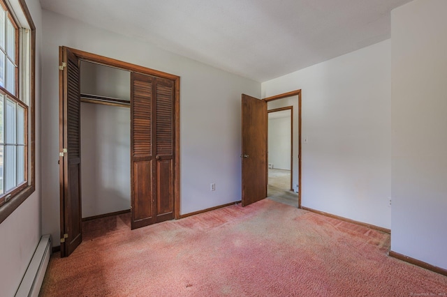 unfurnished bedroom featuring carpet, a closet, and baseboard heating