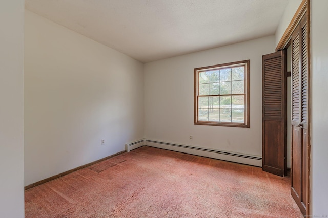 unfurnished bedroom featuring baseboard heating, a closet, light carpet, and a textured ceiling